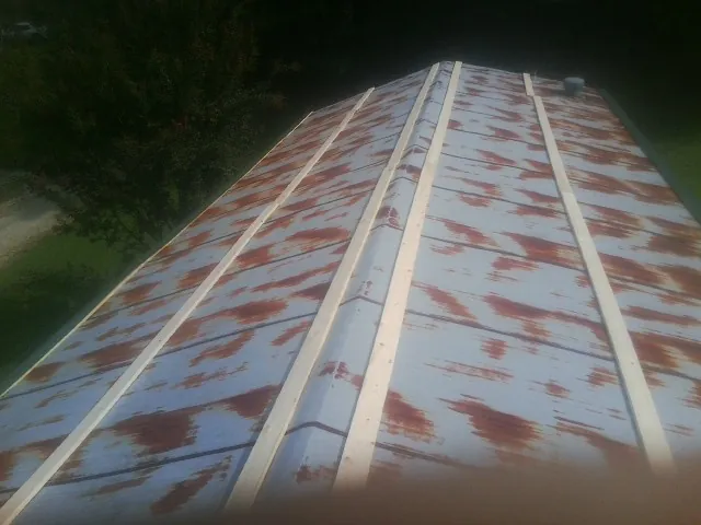 Rusted metal roof panels with new wood purlins before replacement — Storm Damage Roof Repair in Toano by Roofing Brothers
