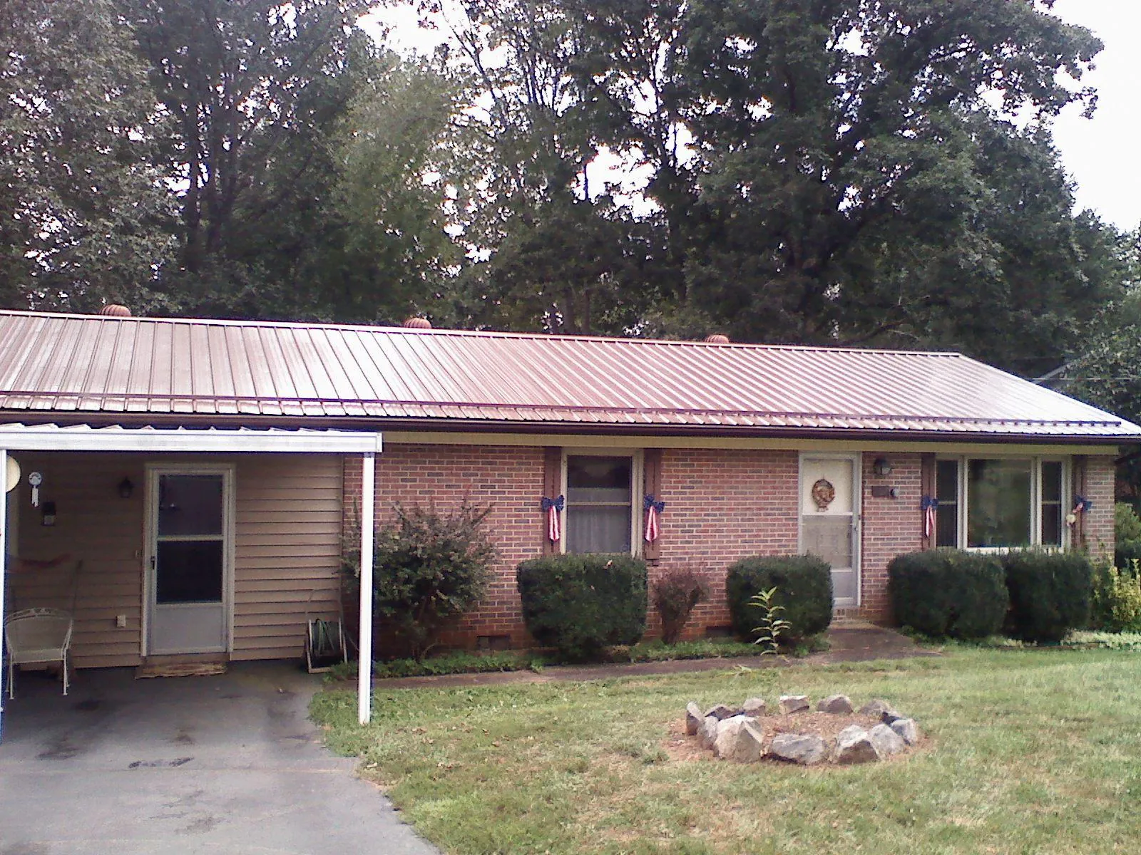 Bronze metal roof and carport on a brick ranch home — Roof Repair work by our crew in Toano