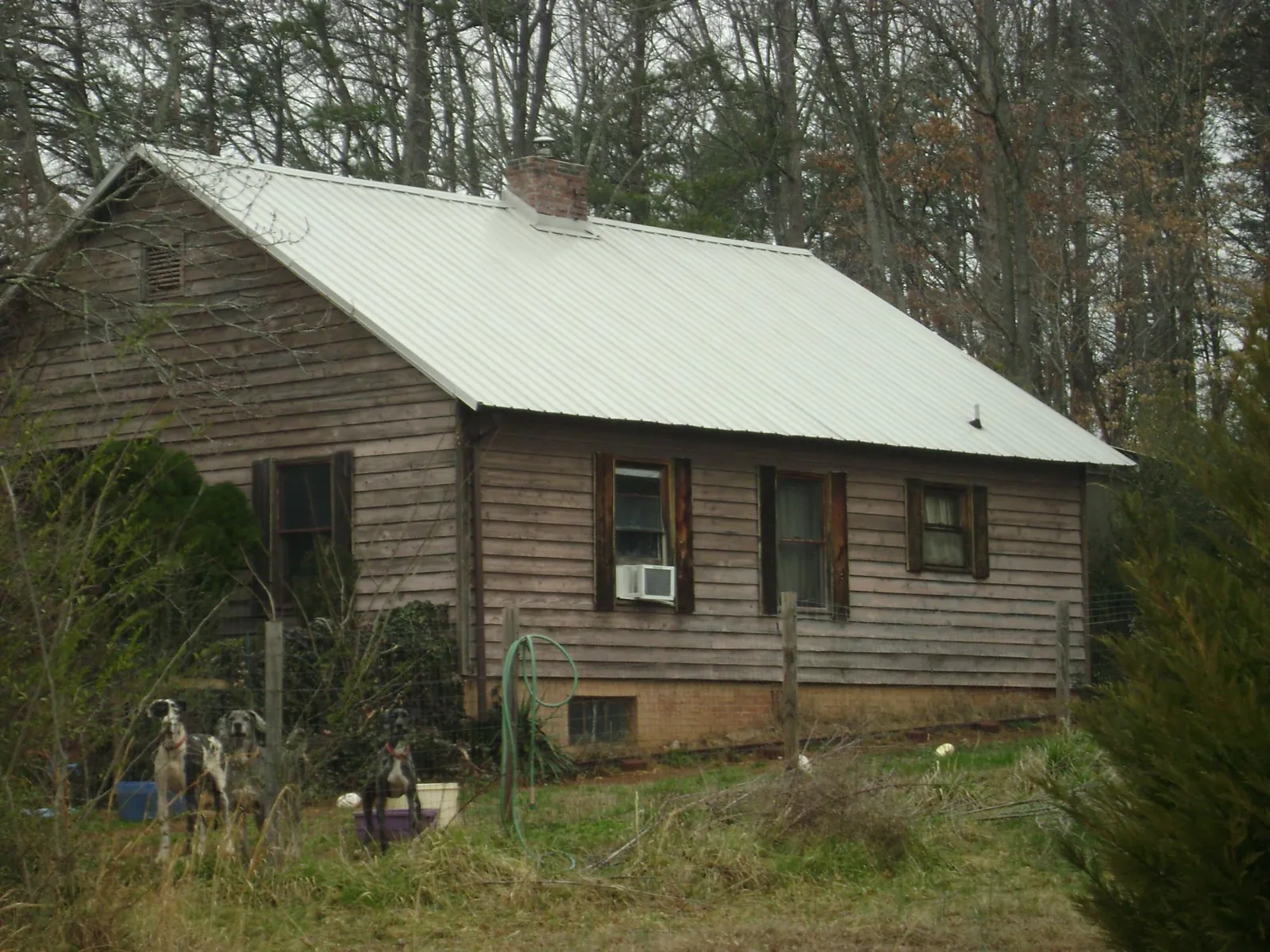White metal roof on an old wood sided farmhouse, from a Metal Roof Installation job in Toano